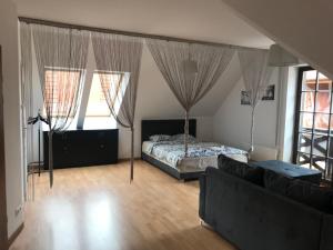 a bedroom with a bed and a couch at Apartament Sunrise in Mikołajki