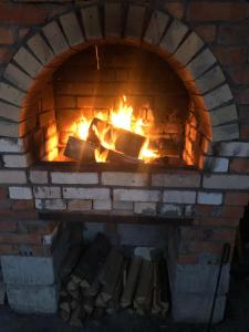 a brick oven with a fire in it at Sadyba Domashniy zatyshok in Pilipets