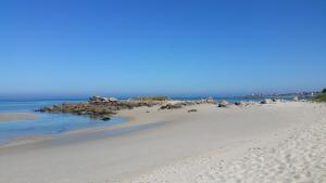 una playa con un montón de rocas y el océano en Résidence de Nodeven en Guissény