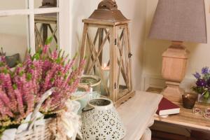una mesa con un jarrón de flores y una lámpara en Villa Scarponi Assisi en Assisi