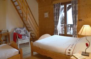 ein Schlafzimmer mit einem Bett, einer Leiter und einem Stuhl in der Unterkunft Les Pralets Plus in La Magne