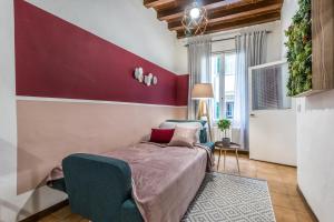 um quarto com uma cama e uma parede em tons de vermelho em Wine Apartments Florence Sangiovese em Florença