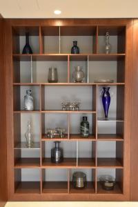 une étagère en bois avec des vases et des vases dans l'établissement Lake Como Holiday Apartments, à Côme