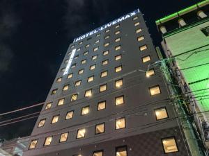 um edifício alto com luzes em cima em HOTEL LiVEMAX Shinjuku Kabukicho em Tóquio