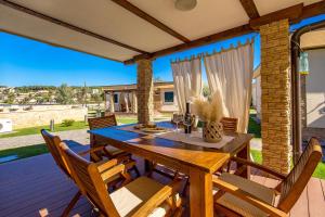 a dining room with a table and chairs on a deck at Lando Resort in Rab