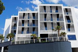 a white building with palm trees in front of it at Lifestyle Hotel Vitar - Adults Only in Bol