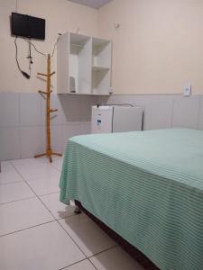a room with a bed with a green blanket on it at Pousada Kaka in Teresina
