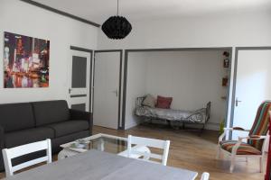 een woonkamer met een bank en een tafel bij La comédie in Lons-le-Saunier