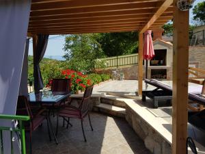 a patio with a table and chairs and an umbrella at Studio-Apartman-Diana in Brseč