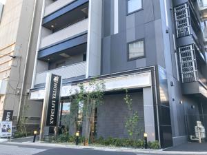 a building with a store front on a street at HOTEL LiVEMAX Chiba Soga-Ekimae in Chiba