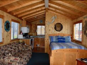 a bedroom with a bed and a couch in a cabin at Driftwood Inn in Homer