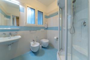 a bathroom with a sink and a toilet and a shower at Hotel Mimosa in Lignano Sabbiadoro +44 photos