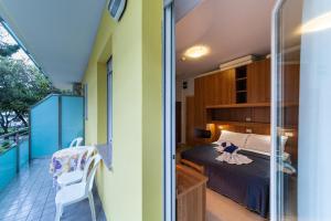 a bedroom with a bed and a balcony at Hotel Mimosa in Lignano Sabbiadoro