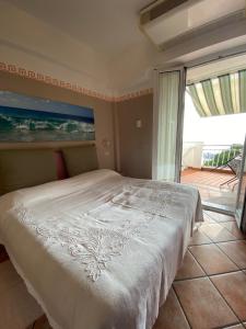 a bedroom with a white bed with a view of the ocean at Appartamenti La Pineta in Marina di Andora