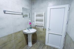 y baño con lavabo blanco y espejo. en City Hotel Kutaisi en Kutaisi