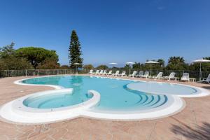 una grande piscina con sedie in un resort di Happy Days a Capo Vaticano