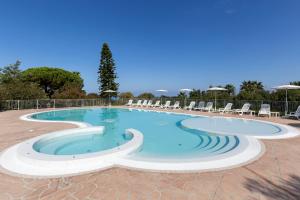 a large swimming pool with chairs in a resort at Happy Days in Capo Vaticano