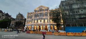 فندق ريغال بلازا في مومباي: مبنى كبير فيه سيارات تقف امامه
