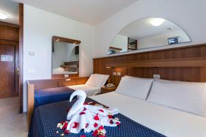 Hotel Vina De Mar في لينانو سابيادورو: غرفة نوم عليها سرير وبجعة