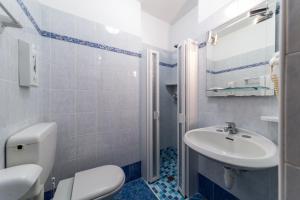 bagno con servizi igienici bianchi e lavandino di Hotel Vina De Mar a Lignano Sabbiadoro