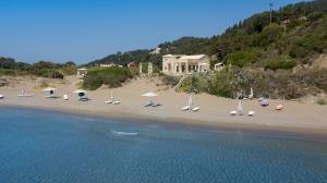 un grupo de sillas y sombrillas en una playa en Acantha Boutique Hotel en Ereikoússa