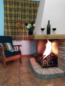 una chimenea con 2 copas de vino en una habitación en Alojamiento valeria, en Arroyo Frío