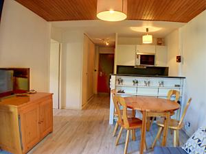 Il comprend une cuisine et une salle à manger avec une table et des chaises en bois. dans l'établissement Aster, à Chamonix-Mont-Blanc