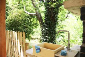 un lavandino su un tavolo di fronte a un albero di Casa Vacanze Il Giardino - Appartamento Castagno ad Aritzo