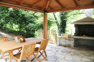un tavolo e sedie in legno su un patio con camino di Casa Vacanze Il Giardino - Appartamento Castagno ad Aritzo