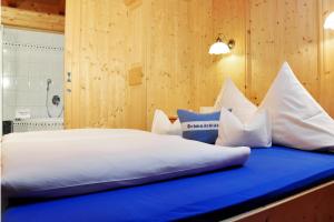 a bedroom with a large white bed with a blue cushion at Appartment Maurer in Oetz