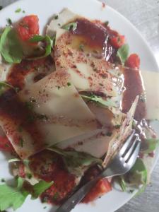 une assiette de nourriture avec une salade et une fourchette dans l'établissement I Dolci Grappoli, à Larino