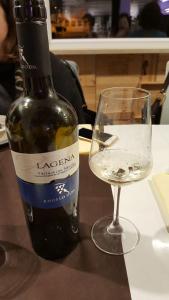 una botella de vino y una copa en una mesa en I Dolci Grappoli, en Larino