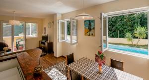 ein Wohnzimmer mit einem Esstisch und Fenstern in der Unterkunft Villa Relax in Herceg-Novi