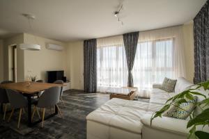 a living room with a white couch and a table at Penthouse at White Cliffs in Byala +23 photos