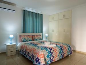 ein Schlafzimmer mit einem Bett mit einer bunten Bettdecke in der Unterkunft Sirena Resort Curaçao in Willemstad + 19 Fotos