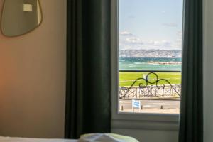 マルセイユにあるホテル ル ミストラルの海の景色を望む窓付きの客室です。