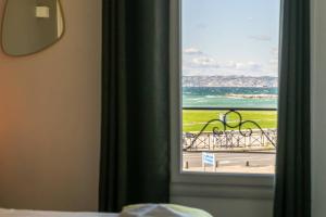 a room with a window with a view of the ocean at Hôtel Le Mistral in Marseille