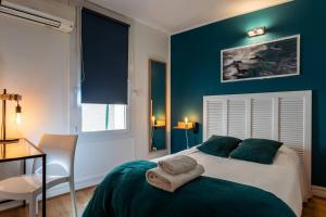 a bedroom with a bed with a blue wall at Hôtel Le Mistral in Marseille