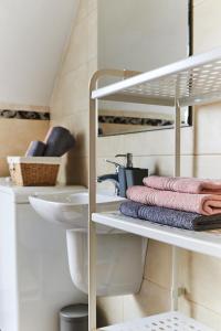 a bathroom with a sink and towels on a shelf at Apartament Z Widokiem in Polanica-Zdrój