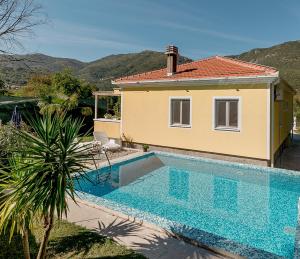 a villa with a swimming pool in front of a house at Villa Relax in Herceg-Novi