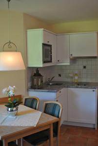 a kitchen with white cabinets and a table with chairs at Kornbranntgut Hieflau in Hieflau