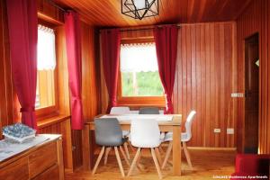 ein Esszimmer mit roten Vorhängen sowie einem Tisch und Stühlen in der Unterkunft Sunlake Magneaz in Champoluc