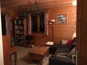 ein Wohnzimmer mit einem Sofa und einem Tisch in der Unterkunft Les Pralets Plus in La Magne