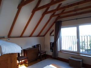 a bedroom with a bed and a large window at Rose Cottage studio in Sheffield