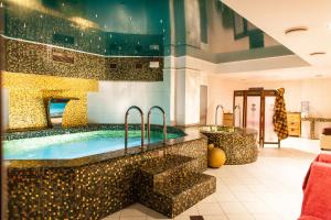 a bathroom with a large swimming pool with a tub at TB Palace Hotel & SPA in Jūrmala