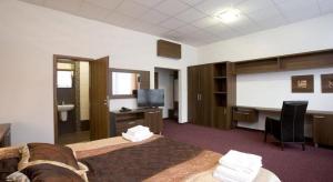 a room with a bed and a flat screen tv at Garni Hotel Branč in Senica