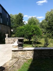 una pared de piedra con una fuente en un jardín en Le Clos des Cygnes, en Charolles