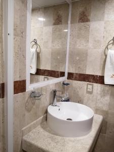 y baño con lavabo blanco y espejo. en Misol-Ha Hotel Mérida, en Mérida