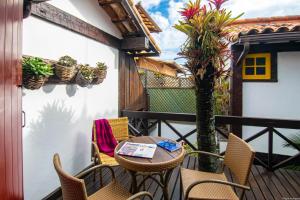 Un patio con sillas y una mesa en el balcón. en Chez Pitu Praia Hotel en Búzios