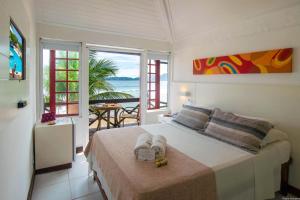 a bedroom with a bed with a view of the ocean at Chez Pitu Praia Hotel in Búzios